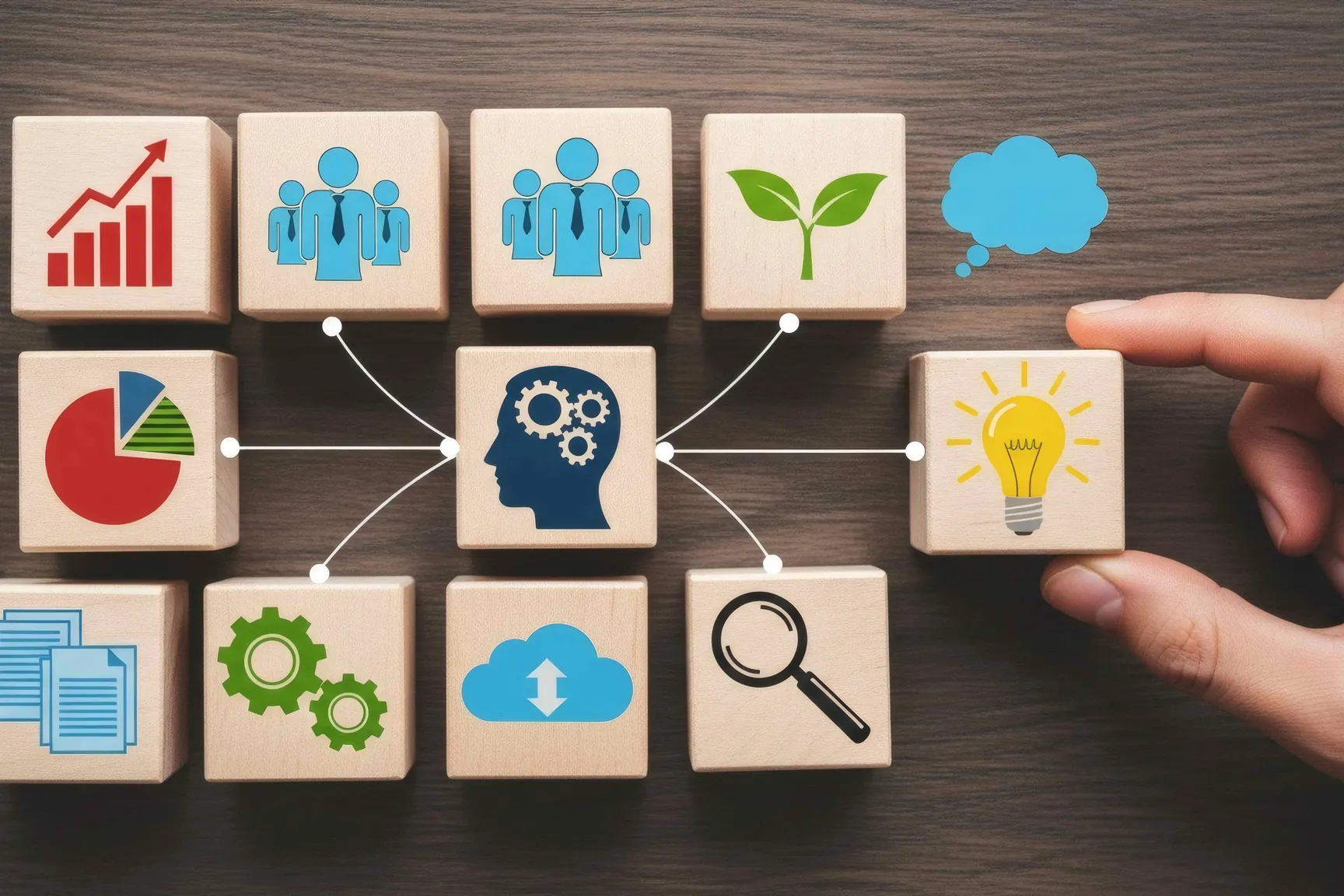 verschillende houten blokken met daarop iconen zoals een stijgende grafiek, een groep personen, een plant, een taartdiagram, een lamp, documenten, tandwielen en een vergrootgals.