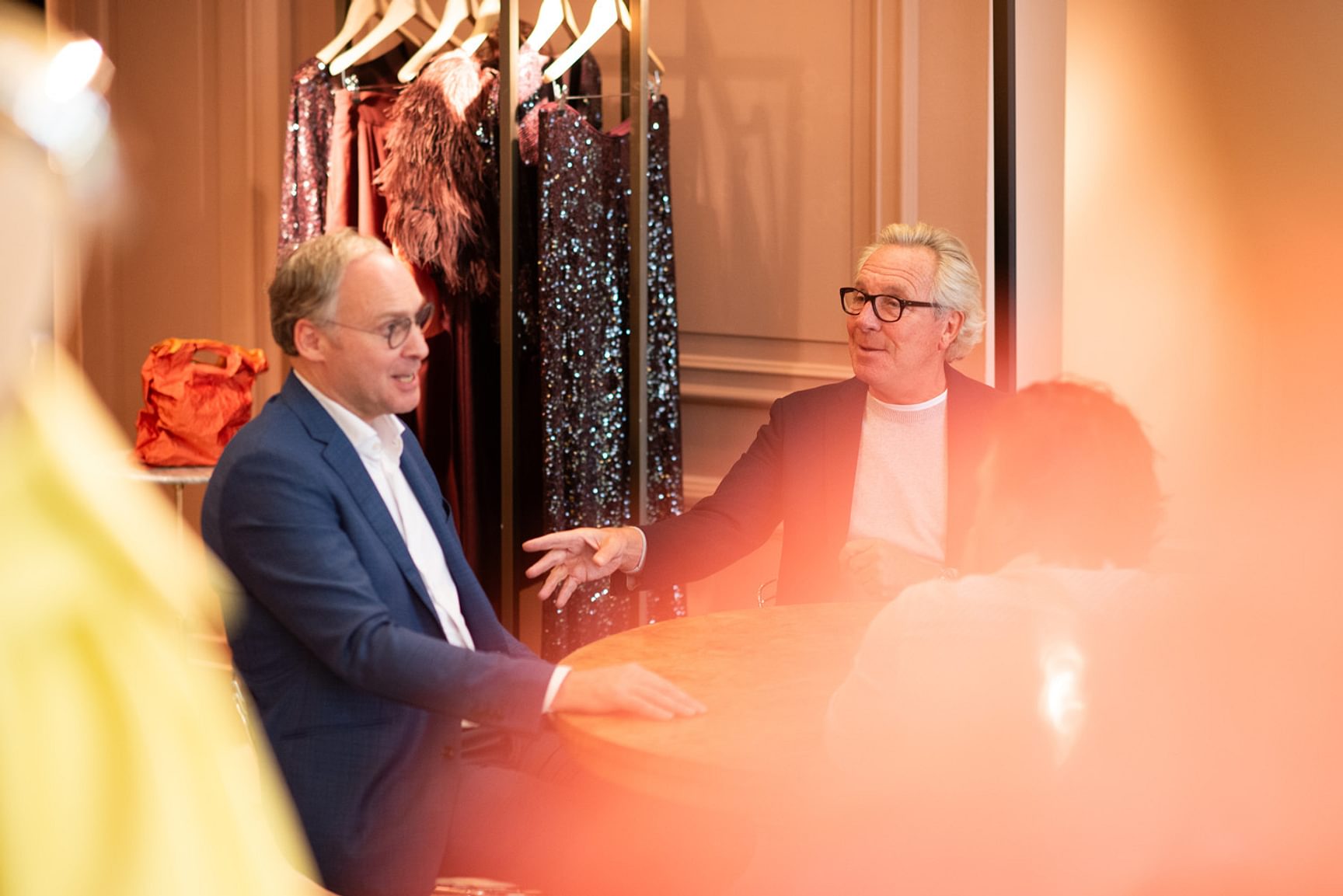 Een afbeelding van een gesprek tussen twee personen in het modehuis NATAN.