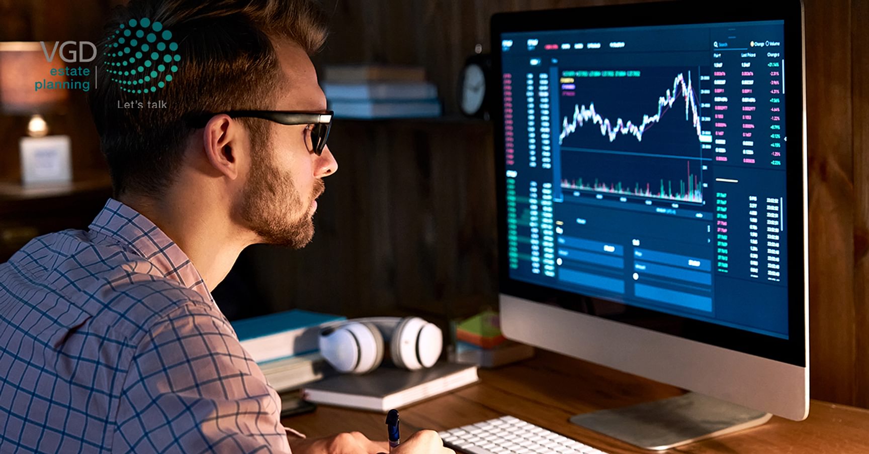 Persoon kijkt naar een computerscherm met beursgrafieken en financiële data.