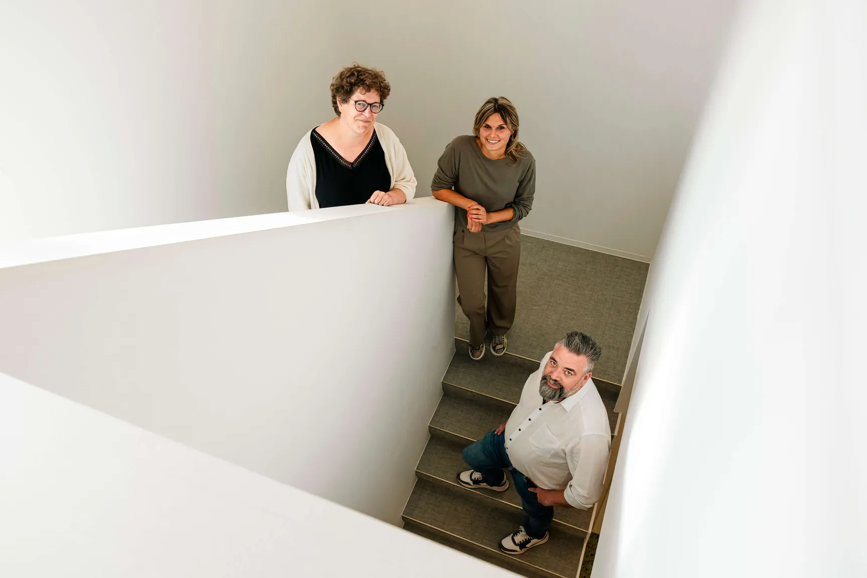2 VGD-medewerkers en 4D Trans op een trap in een modern kantoor.