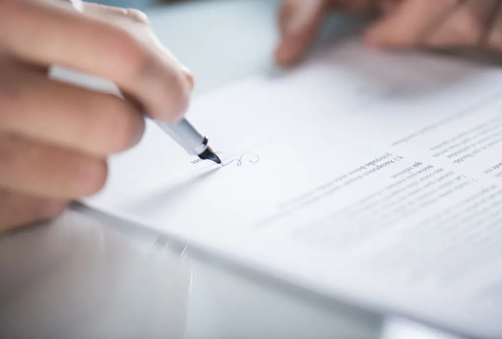 Hand dat een document ondertekent met een pen.