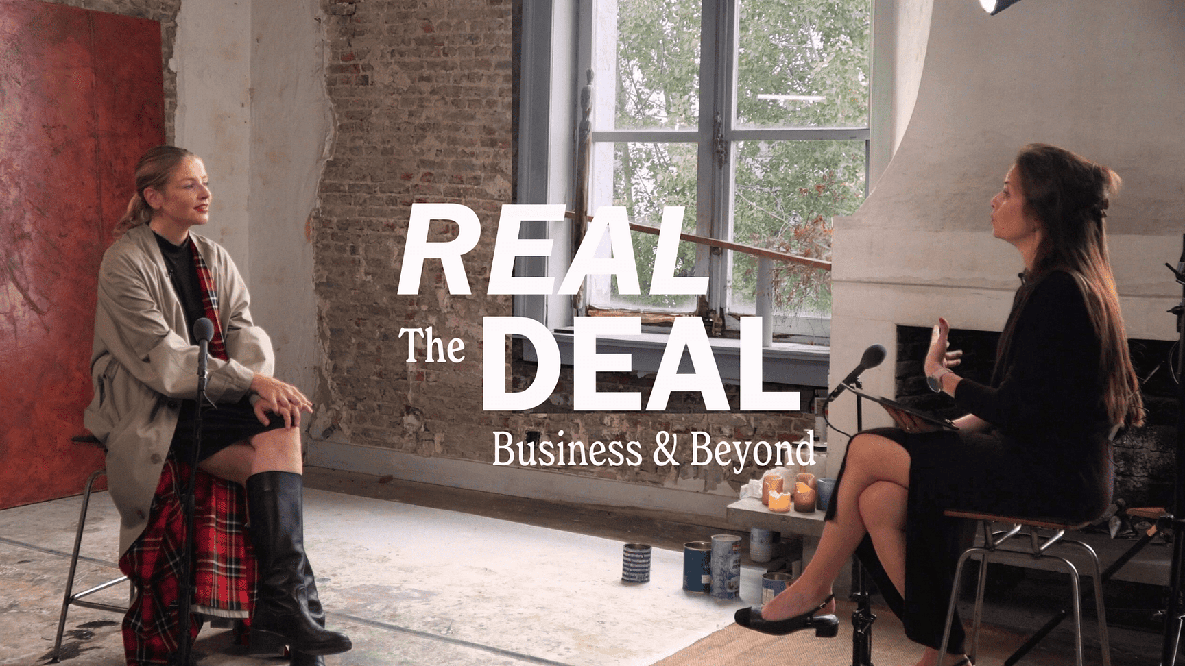Beel van een podcastopname van The Real Deal: Business & Beyond - Monumento, met twee personen in gespren in een professionele interviewsetting.